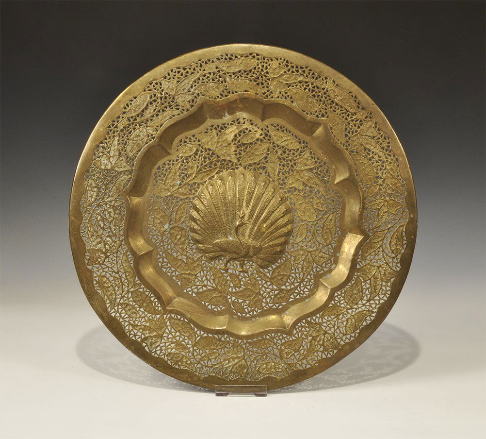 Islamic Persian Style Bronze Openwork Platter with: An undated archaistic openwork bronze platter with rolled rim, central peacock motif surrounded by a tracery of leaves and tendrils. 540 grams, 37.5 cm (14 3/4"). Acquired on the London art market bef