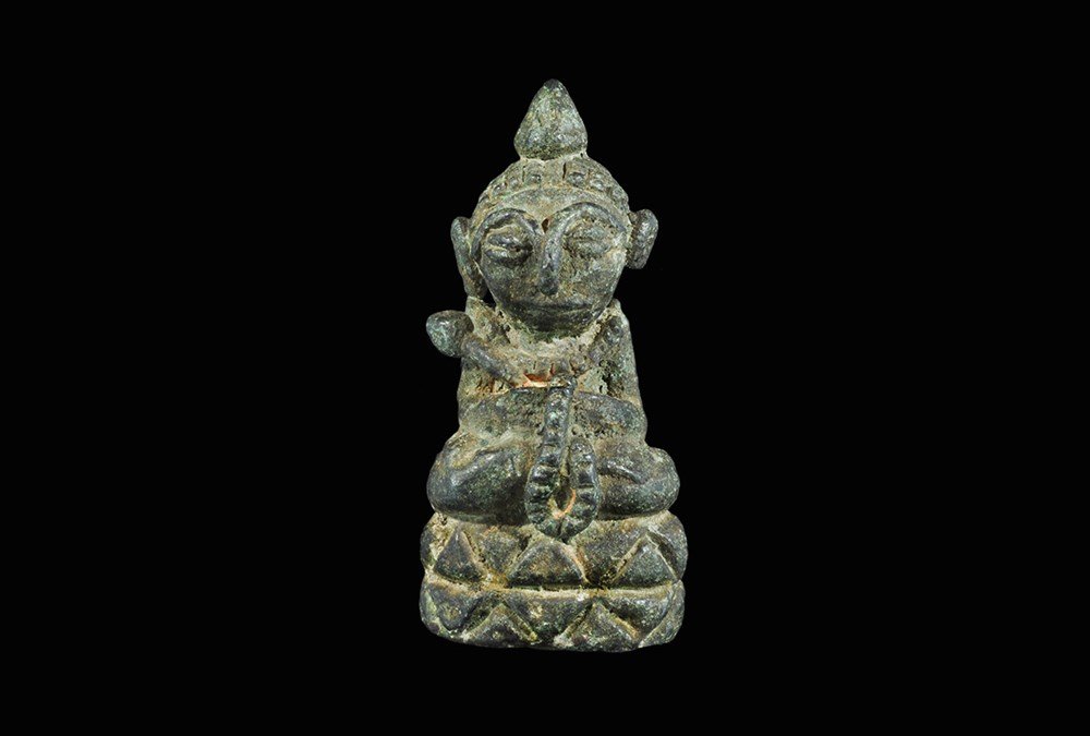 Indian Bronze Snake Charmer Statuette: An undated archaistic cast statuette of a cross-legged figure with basket in its lap, snake's head escaping left; coil to the underside. 46 grams, 44 mm (1 3/4"). Property of a London collector, acqui