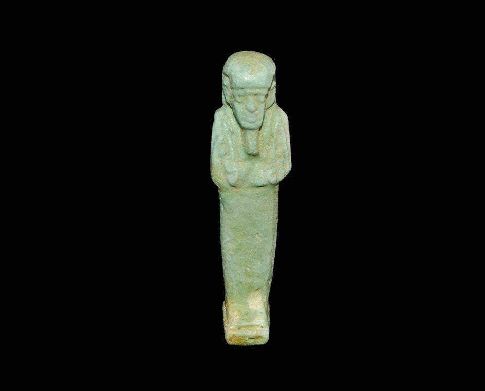Egyptian Style Glazed Composition Shabti: An undated archaistic pale blue shabti with plaited beard, agricultural implements, dorsal pillar and square base. 20 grams, 70 mm (2 3/4"). Acquired on the London art market in the 1980s. [No Reserve