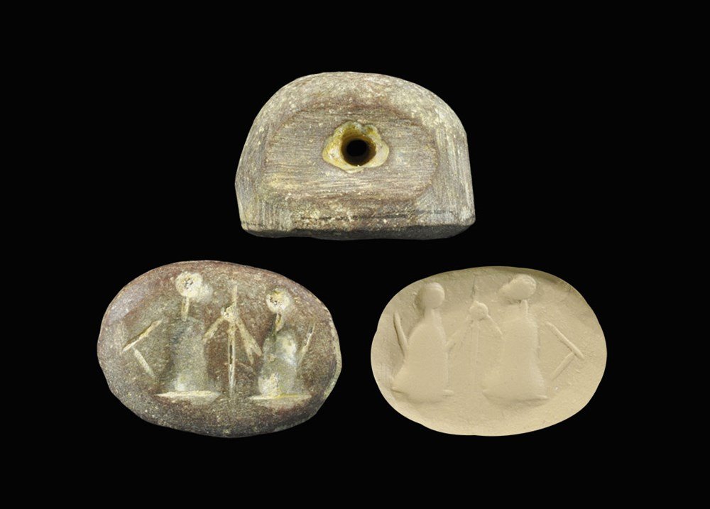 Near Eastern Sumerian Style Stone Stamp Seal with: An undated archaistic D-shaped stamp seal in 2nd millennium BC style, with recesses to the sides and piercing, elliptical in plan with intaglio design of two standing figures and a staff. 15 grams, 28