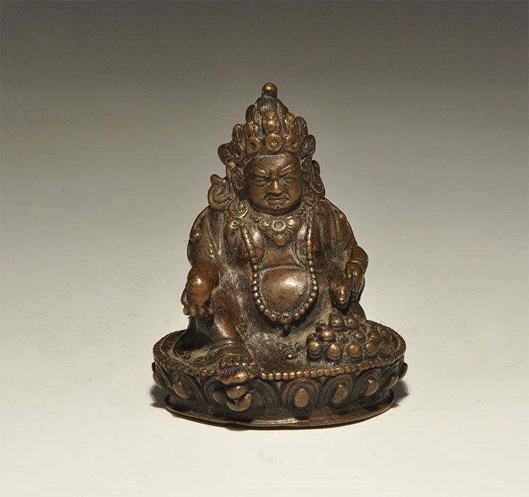 Chinese Tibetan Style Bronze Buddha Statuette: An undated archaistic cast bronze statuette of the Buddha seated on a lotus throne holding an egg and a rodent; hollow to the underside. 240 grams, 80 mm (3 1/4"). Property of a London collector, acqu