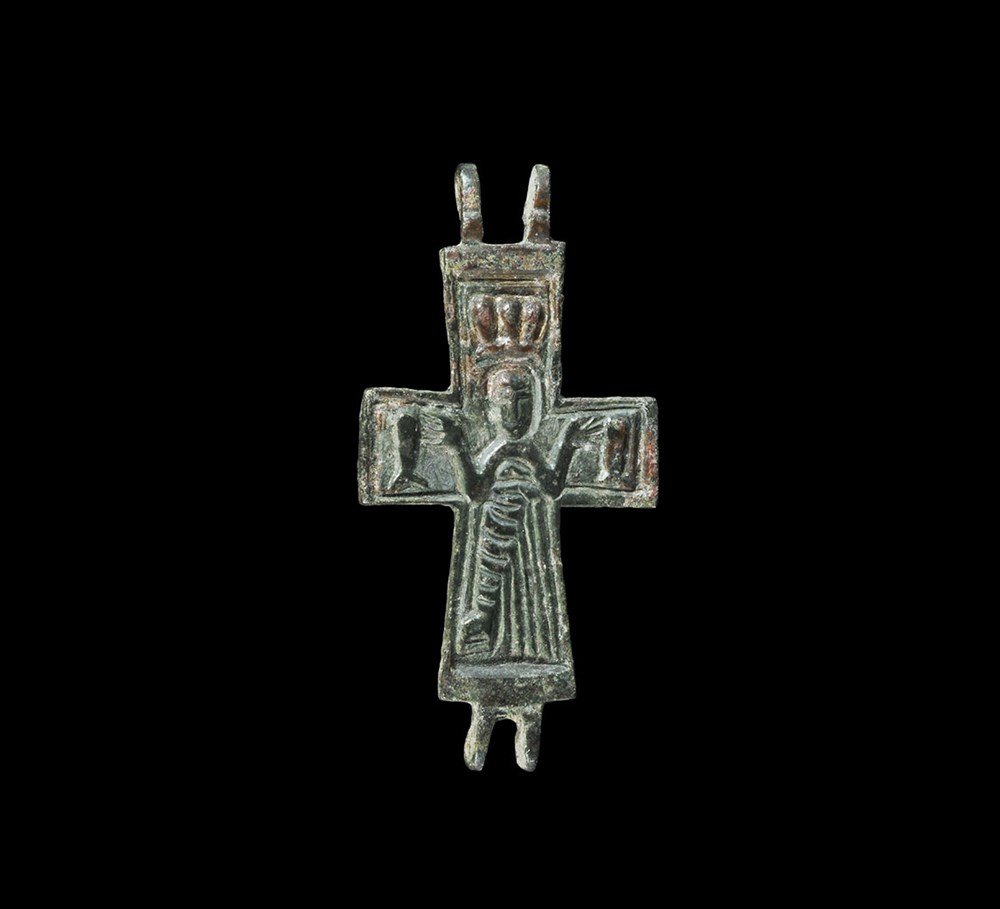 Byzantine Bronze Cross Pendant: 5th-8th century AD. A cast frontal plate from a cruciform reliquary pendant with hinge lugs top and bottom with high-relief image of Christ robed with objects in the field. 13 grams, 64 mm (2 1/2"). P