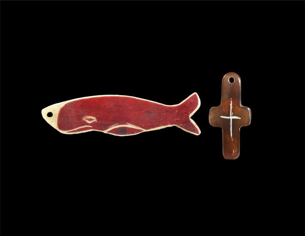 Post Medieval Whalebone Pendant and Tortoiseshell Cross: 19th century AD. A group of two pendants comprising: a whalebone plaque in the shape of a whale, red pigment, carved detail to one face; a tortoiseshell cruciform pendant with incised cross to one fac