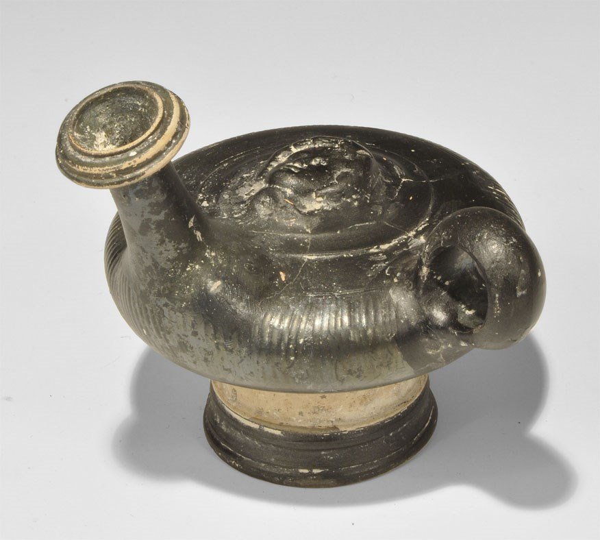 Greek Apulian Ceramic Guttos with Facing Head: 4th century BC. A blackware guttos with pedestal base, single loop handle and tall spout with collar; to the centre, a female face modelled in the half-round. 309 grams, 14 cm (5 1/2"). From the estat
