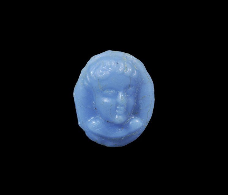 Roman Blue Chalcedony Bust Cameo: 2nd-3rd century AD. A carved plaque, elliptical in plan, with a youthful male bust modelled in the half-round. 0.75 grams, 12 mm (1/2"). From a North London collection; acquired in Miami in the 1990s.