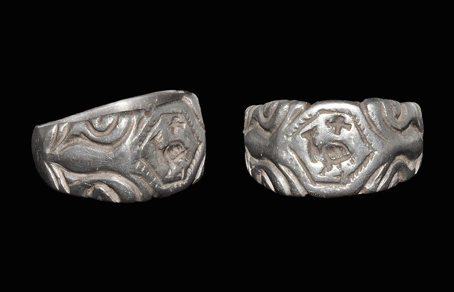 Byzantine Silver Seal Matrix Ring: 7th-10th century AD. A flat-section hoop expanding to trapezoidal shoulders and bezel; the hoop facetted at the rear, the shoulders with addorsed scrolls, the bezel with octagonal panel, ropework bord