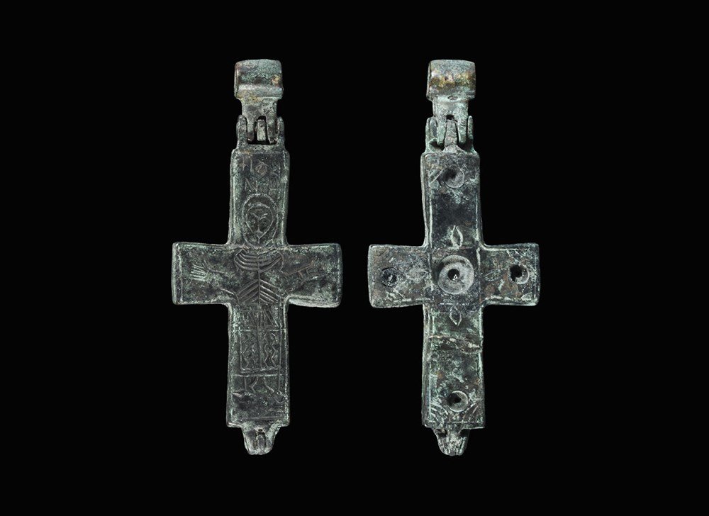 Byzantine Bronze Reliquary Cross Pendant: 6th-9th century AD. A cast reliquary cross pendant with two concave halves and separate articulated suspension loop; to the obverse recesses for five glass inserts (one remaining); to the reverse, inc