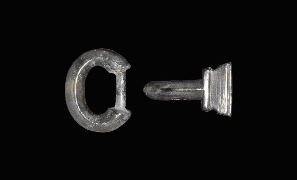 Merovingian Billon Silver Buckle: 6th-7th century AD. A two-part buckle comprising: a reniform loop with concave underside, narrow rear bar; a hooked tongue with trapezoidal plate to the rear, transverse ridges. 37 grams, 36 mm (1 1/4