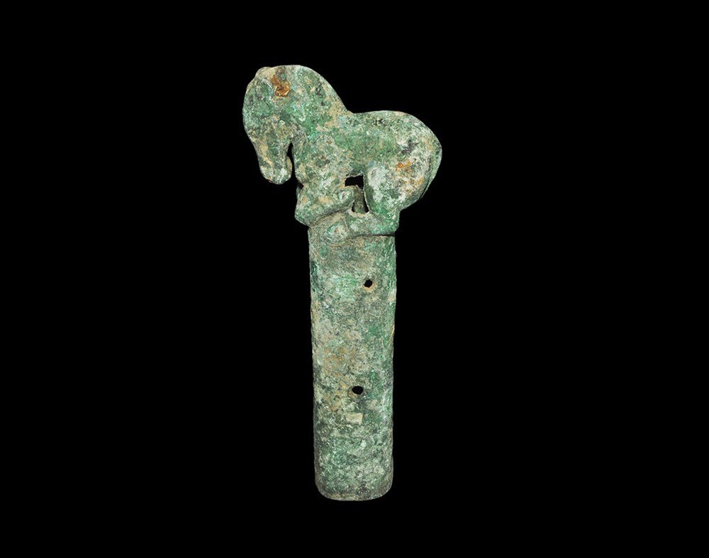 Central Asian Perm Kama Bronze Handle with Horse Finial: 1st millennium BC. A cast tubular grip with opposed holes for attachment pins; above, a horse modelled in the round. 289 grams, 15.5 cm (6"). Russian private collection, formed in the 1950s.