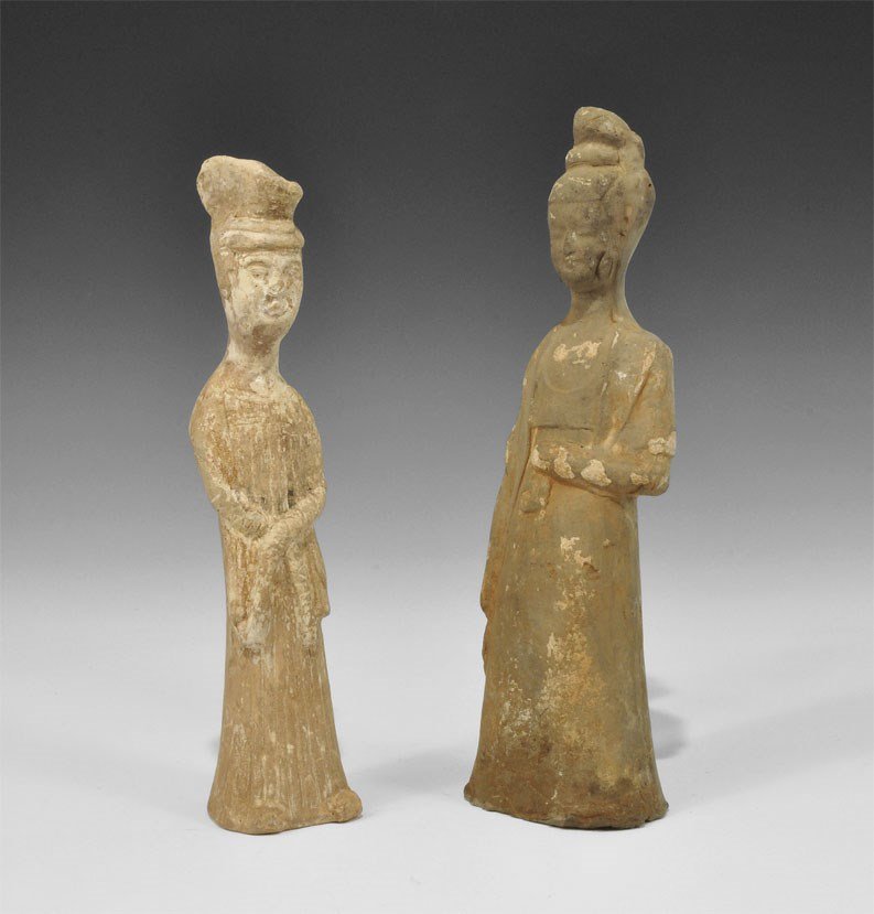 Chinese Ceramic Female Attendant Statuette Pair: Han Dynasty, 206 BC-220 AD. A mixed group of hollow-cast figurines comprising: a courtly lady with left hand to the midriff; another similar with hands crossed on the abdomen, slippers partly visible 