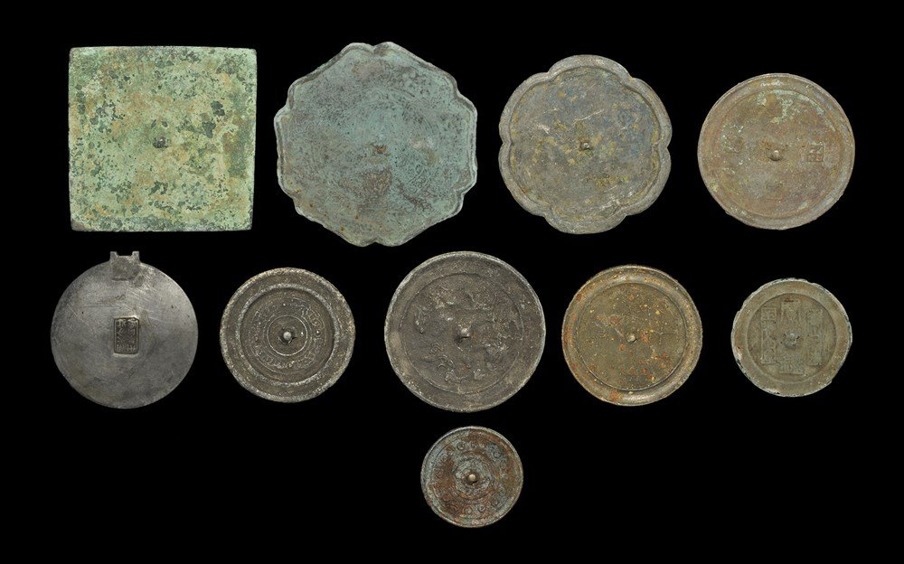 Chinese Bronze Mirror Group: Han and Tang Dynasties, 206 BC-916 AD, and two later. A mixed group of cast mirrors comprising: one discoid, character to the reverse repeated four times; one similar, running animal motifs; one simil