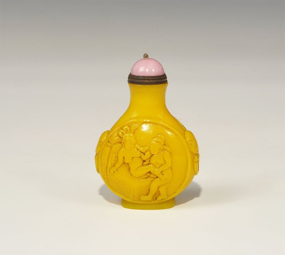 Chinese Style Glass Erotic Perfume Bottle: An undated archaistic carved glass bottle with domed lid and spoon, erotic scenes to the two faces and faux loop hanles to the sides; incised signature to the underside. 76 grams, 74 mm (3"). Property