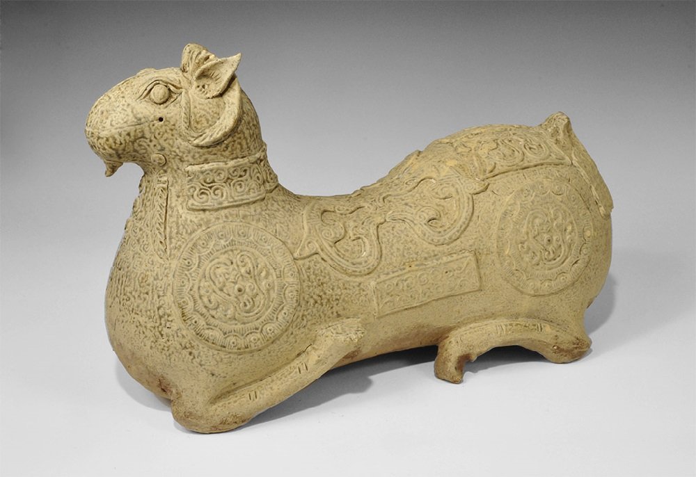 Cambodian Style Glazed Ceramic Ram Vessel: An undated archaistic grey-glazed vessel with a hole to the upper surface of the head, loop to the rump, scrolled decoration to the body. 8.7 kg, 47 cm (18 1/2"). From a South West London collection; 