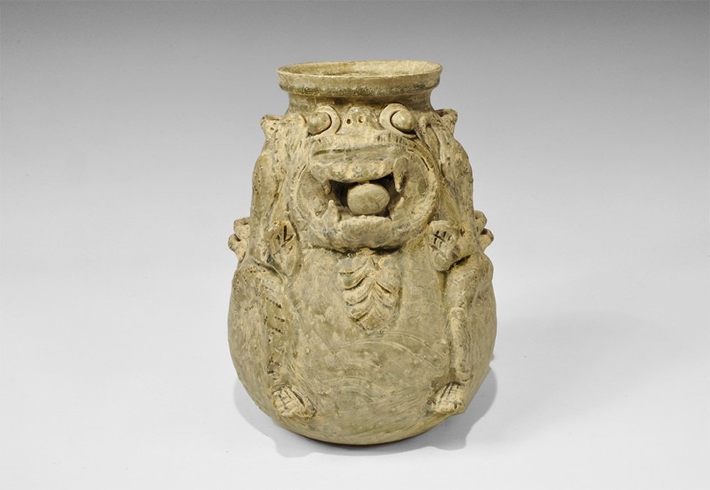 Cambodian Style Glazed Ceramic Lion Jar: An undated archaistic gourd-shaped vessel with broad neck and flange rim, applied elements of a stylised lion's body to one face, six lateral loops and series of spines to the reverse. 2.6 kg, 25 cm (