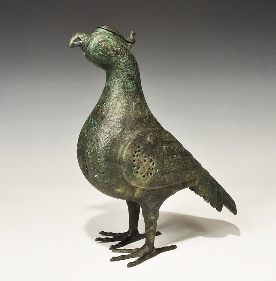 Islamic Style Bronze Calligraphic Incense Burner with: An undated archaistic openwork incense burner in the form of a standing bird with feather detailing to the neck, body, legs and head; the chest, back and wings in openwork, foliage and silver-inlaid h