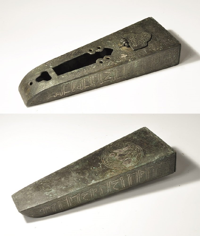 Islamic Style Bronze Calligraphic Pen Box with Silver: An undated archaistic sheet bronze pen box with tray to the rear, D-shaped hinged lid and ornamental voids to the upper face; silver-inlaid calligraphic text to the sides and upper face, geometric mot