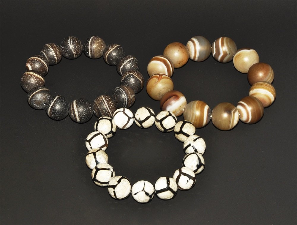Chinese Style Agate and Glass Bead Bracelet Group: A mixed group of restrung bracelets of undated archaistic globular beads comprising two in banded agate and one in etched glass, Pumtek style. 216 grams total, 19-21 cm (7 1/2 - 8 1/4"). From a South 
