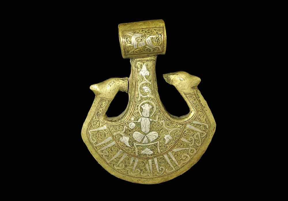 Islamic Style Bronze Silver-Inlaid Axehead: An undated archaistic cast axehead with tubular socket, peltoid blade with addorsed beast-head finials; silver-inlaid running hare to the socket, seated figure to the blade and band of calligraphic te