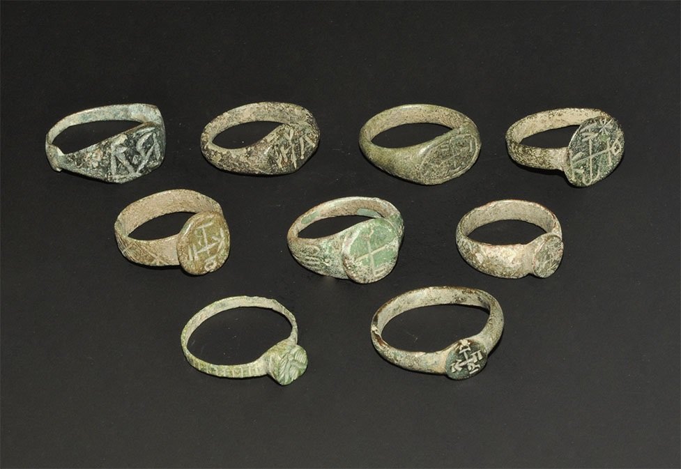 Byzantine Bronze Monogram Ring Group: 10th-14th century AD. A mixed group of bronze fingers rings, each with a monogram or geometric motif to the bezel. 39 grams total, 21-24 mm (3/4 - 1"). Ex south German collection; formed before 1975.