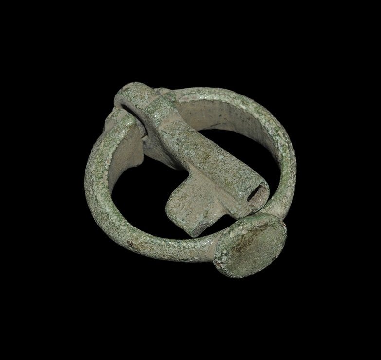 Byzantine Bronze Ring Key: 7th-8th century AD. A D-section hoop with discoid bezel, flared ends with ribbed collars flanking a narrow spigot retaining a small key with hole and single ward. 10 grams, 44 mm including key (1 3/4"