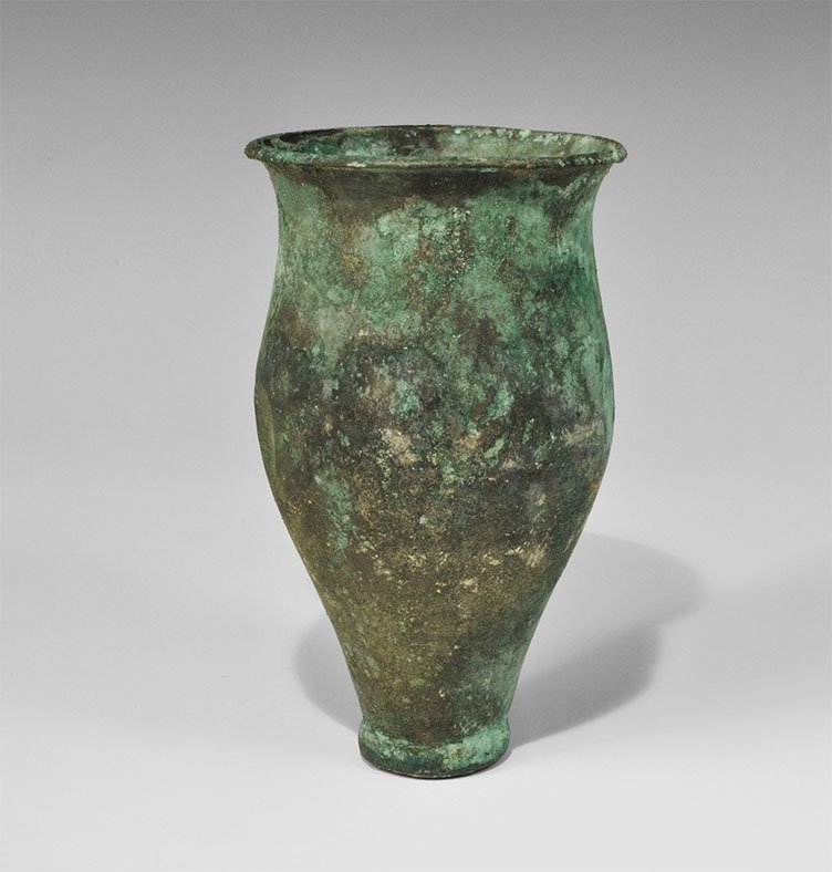 Near Eastern Achaemenid Bronze Goblet: 5th-4th century BC. A tall drinking vessel with narrow discoid foot, bell-shaped body and everted rim with chamfered lip. Acquired on the London art market prior to 1980. 358 grams, 16 cm (6 1/4"). Ti