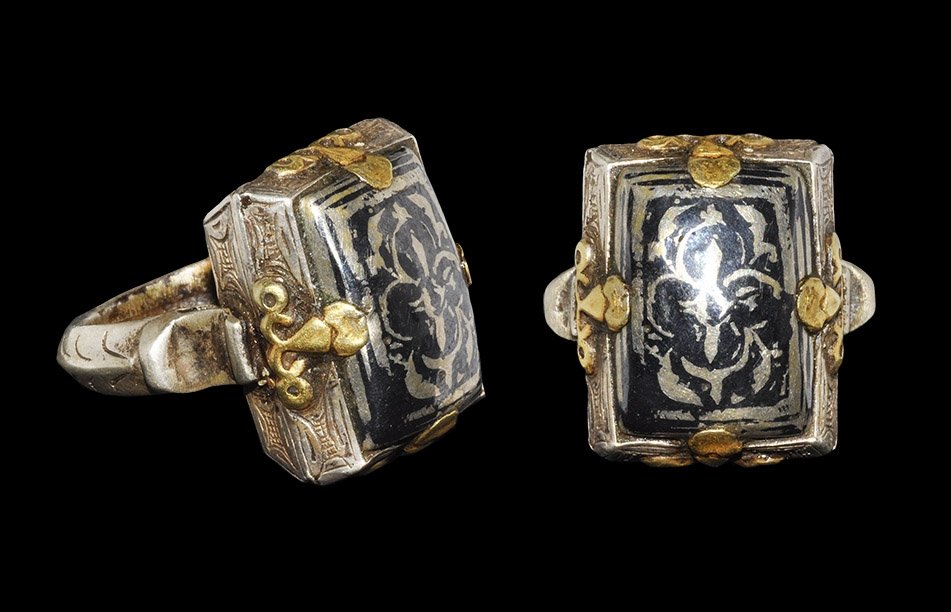Islamic Silver-Gilt Reliquary Box Ring: 19th century AD. A thick carinated hoop with crescent markings, scooped shoulders supporting a miniature casket with hatched detailing to the lower faces, gilt fittings and domed lid with niello roset