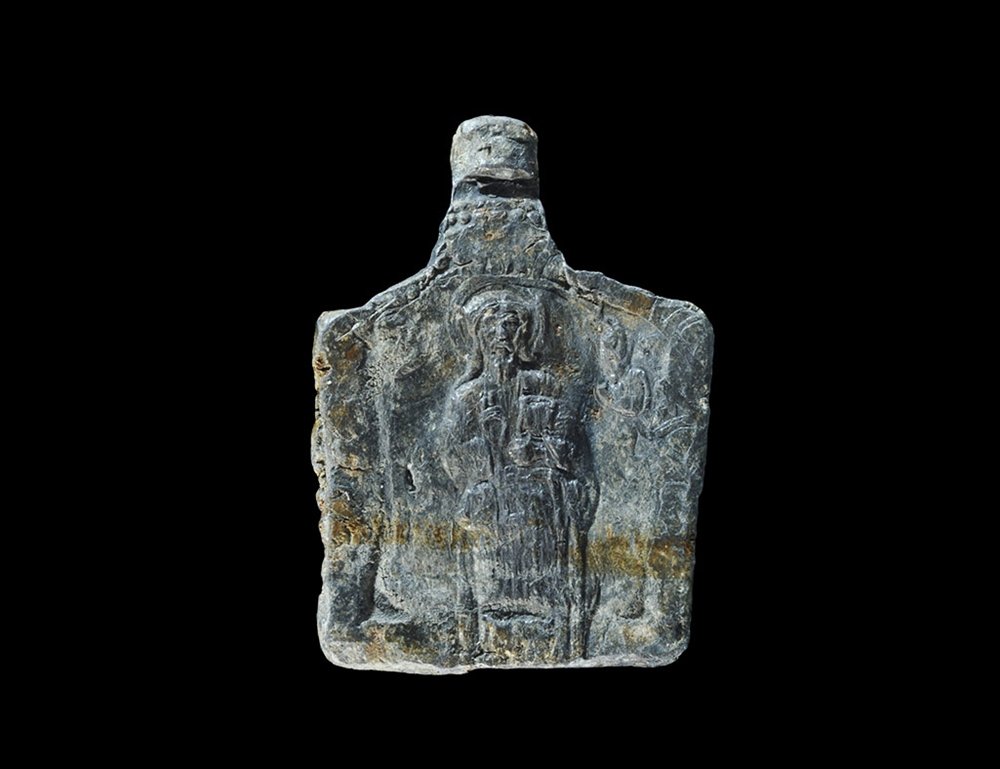 Byzantine Plaque with Figure of Christ: 8th-12th century AD. A cast rectangular lead plaque with tag to the upper edge, image of a standing robed nimbate figure of Christ with the right hand raised in benediction, left arm holding a book. P
