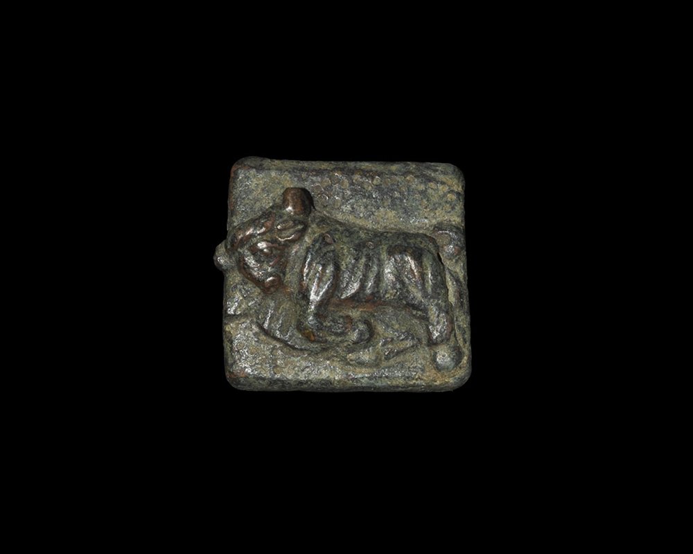 Greek Hellenistic Bronze Charging Bull Coin Weight: 323-30 BC. A cast weight, square in plan and with four pads to the reverse, figure of a charging bull to the upper face modelled in the half-round. From a South German collection, acquired before 1975