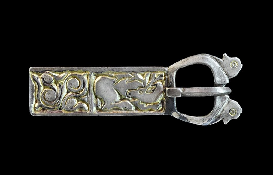 Byzantine Silver-Gilt Horse-Head Buckle with Stag: 7th-8th century AD. A D-shaped buckle with rectangular integral plate; addorsed horse-heads to the chamfered outer face of the loop, each with a ring-and-dot eye; D-section tongue with flat plaque to 