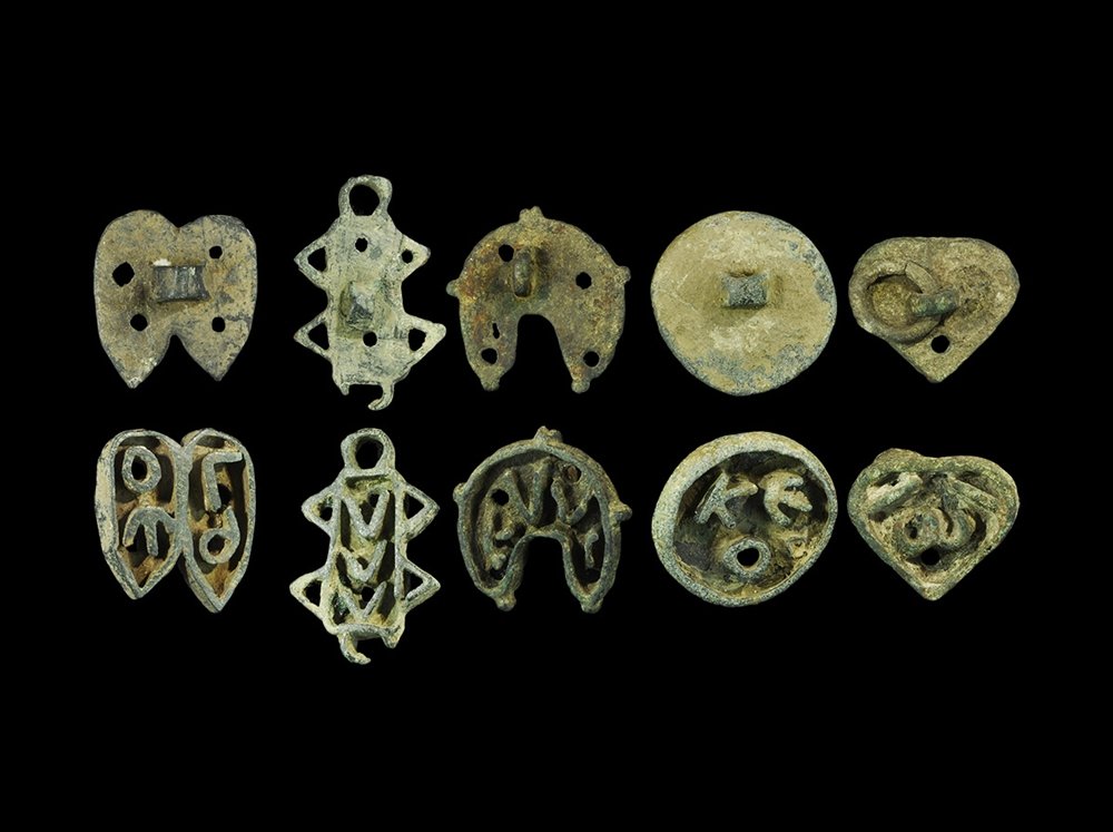 Byzantine Bronze Bread Stamp Group: 5th-8th century AD. A mixed group of cast bread stamps comprising: a rectangle with chevrons to the sides, three chevrons inside; a pair of shoes, four letters inside; a heart, omega inside, loop to r