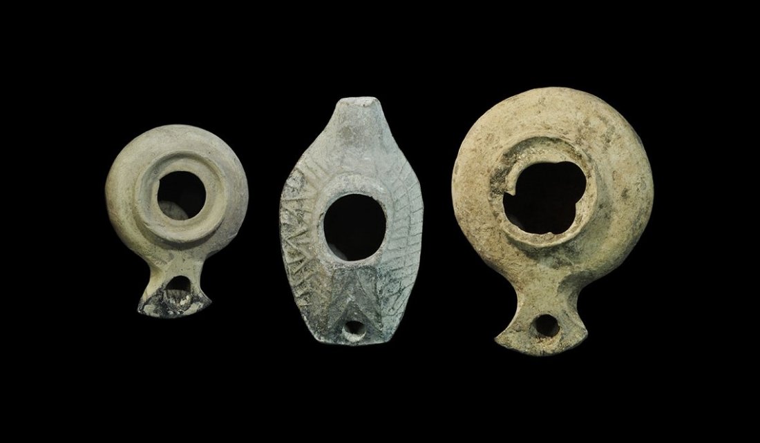 Roman Ceramic Oil Lamp Group: 2nd-6th century AD. A mixed group of ceramic lamps comprising: two discoid with peltoid nozzle; one slipper-shaped of 5th-6th century date, with raised geometric lines to the upper face, stub handle t