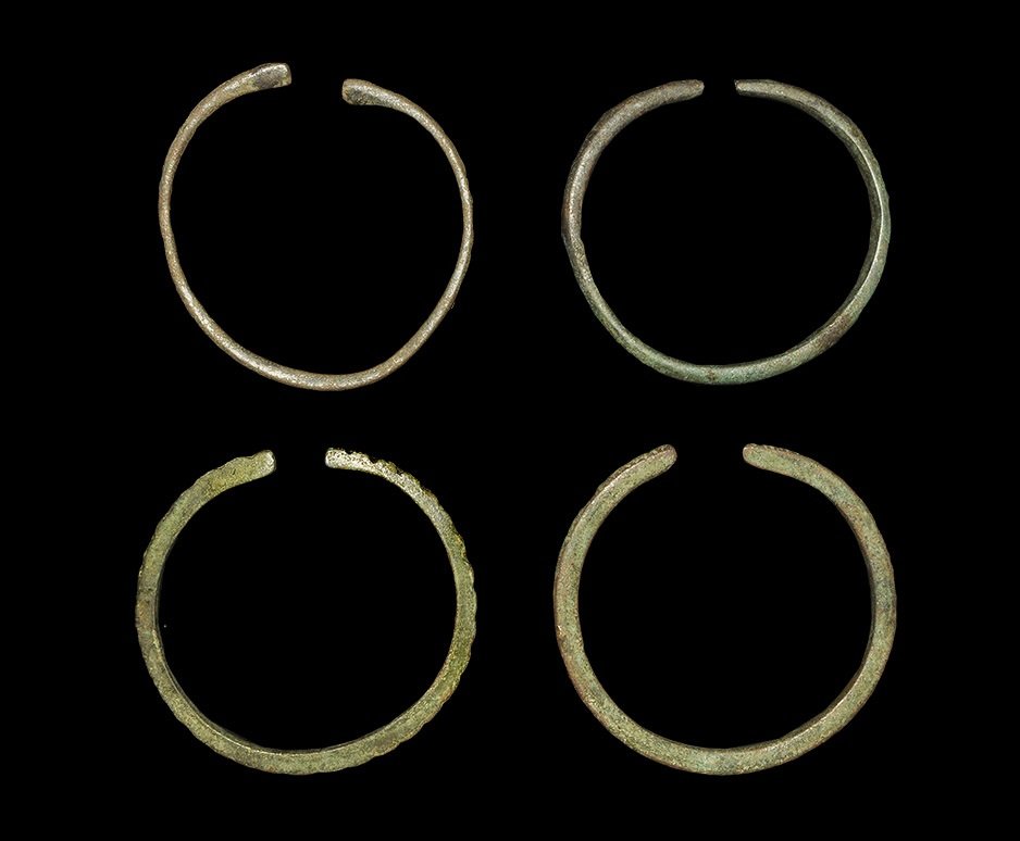 Near Eastern Bronze Bracelets Group: Bronze Age, 1st millennium BC. A mixed group of penannular bracelets comprising: one D-section with clubbed ends; two square-section with serpent detail to the finials; one with dentilled outer face.