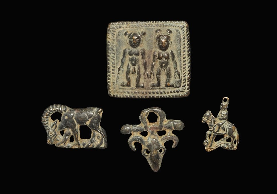 Mongolian Bronze Plaque Group: A mixed group of undated archaistic cast plaques comprising: a grazing ibex; a horseman pendant; an ox-head plaque; a rectangular plaque with two facing figures. 152 grams total, 44-64 mm (1 3/4 - 2 1