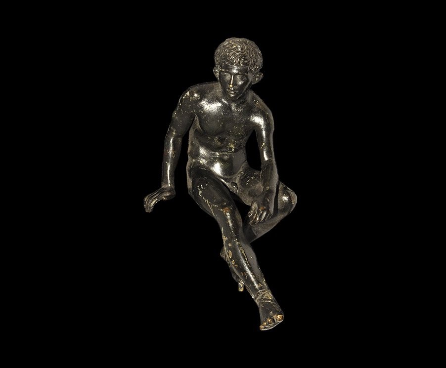 Post Medieval Style Bronze Mercury Statuette: 19th century AD. A hollow-cast black-painted figurine of Mercury as a youth, seated nude with winged sandals to the feet, right hand resting and left arm on the knee; peg to the underside of one foot;