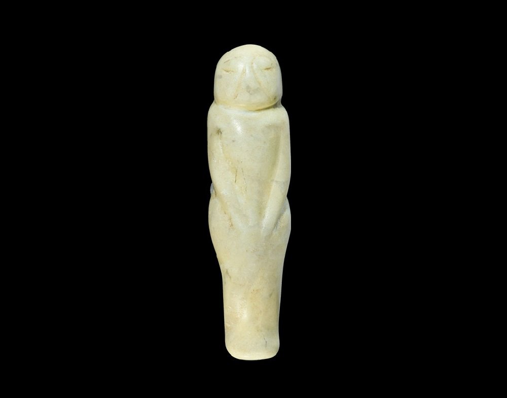 Chinese Stone Figural Pendant: Zhou Dynasty 1046-256 BC or later. A carved amuletic pendant of a standing male with arms held to the front, D-shaped head with incised brows, eyes and slit mouth; pierced to the rear of the neck. 48 