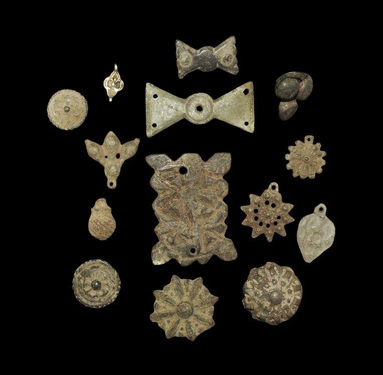 Roman to Post Medieval Bronze Pendant and Belt Mount: 1st century AD and later. A mixed group of mounts and fittings comprising: a trefoil mount with hoop to the reverse; a rectangular mount with foliage detail; five discoid mounts with rosette detail; f