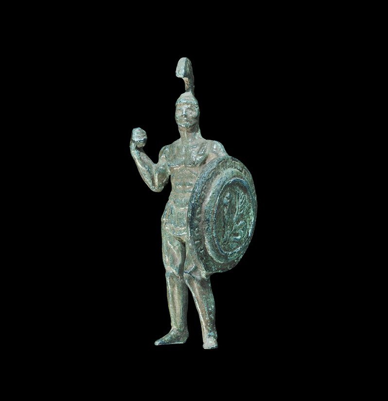 Greek Style Bronzed Gladiator Figure: An undated archaistic spelter(?) figurine of a hoplite with crested helmet, broad round shield and sword. 67 grams, 86 mm (3 1/4"). Property of a gentleman; acquired in the 1990s. TimeLine Auctions Lt