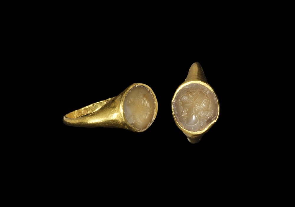 Roman Gold Ring with Maenad Intaglio: 1st-2nd century AD A D-section hoop and integral elliptical bezel with inset chalcedony intaglio bust of a Maenad in profile. Cf. Taylor, G. & Scarisbrick, D. Finger Rings from Ancient Egypt to the Pr