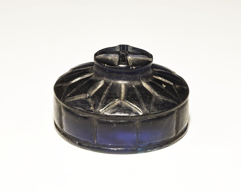 Byzantine Blue Glass Pyxis Lid: 10th-14th century AD A discoid blue glass lid with segmented sidewall, radiating petals to the upper face, raised discoid central panel with cruciform motif. 262 grams, 74 mm (3"). Property of a Maida