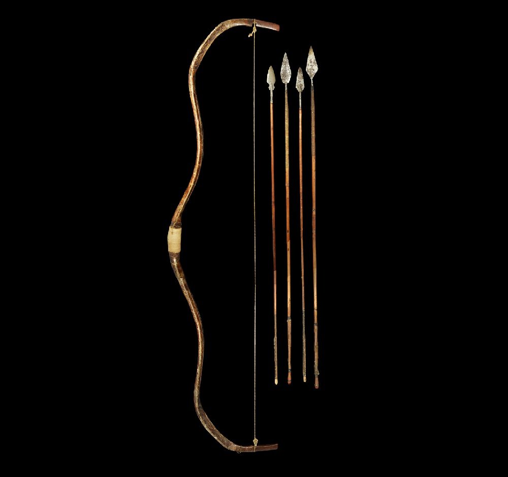 Indian Mughal Gilt and Painted Hunting Bow with Arrows: 17th century AD A painted and lacquered wooden recurved self-bow with integral nocks; the body with running geometric designs to both faces, cord whipping to the grip; sinew cord with loops; four arro