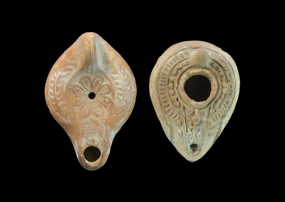 Byzantine Terracotta Oil Lamp Group: 5th-9th century AD. A mixed group of oil lamps comprising: one ochre-coloured, slipper-shaped with conical handle, bands of raised radiating ornament;one discoid with D-shaped nozzle, triangular lug h