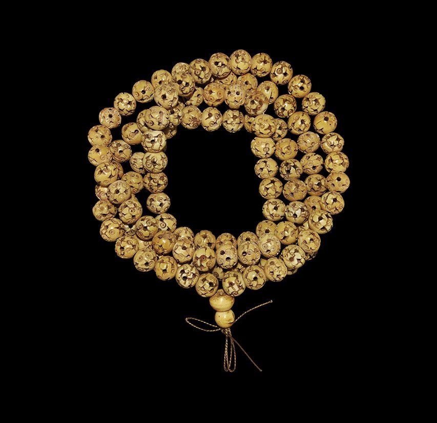 Tibetan Style Composition Bead Necklace: 20th century AD. An archaistic Hindu or Buddhist prayer strand of carved round bone beads decorated with holes and ring-and--dot designs. 124 grams, 118cm (46 1/2"). Ex North London collection; acquir