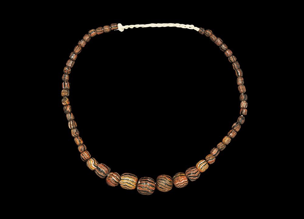 Islamic Style Glass Bead Necklace: 20th century AD. An archaistic graduated necklace of graduated handmade matching glass beads; Indonesian workmanship. 86 grams, 58cm (22 3/4"). From a London collection; formed between 1990-2000. Time