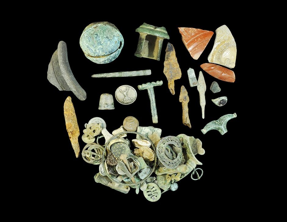 Roman to Post Medieval Metal Detecting Finds Group: 1st-18th century AD. A mixed group of detector and other finds including: a crotal bell; a thimble; a fragment of terra sigillata; an iron miniature knife blade; a ceramic rim with inked notation 'Col
