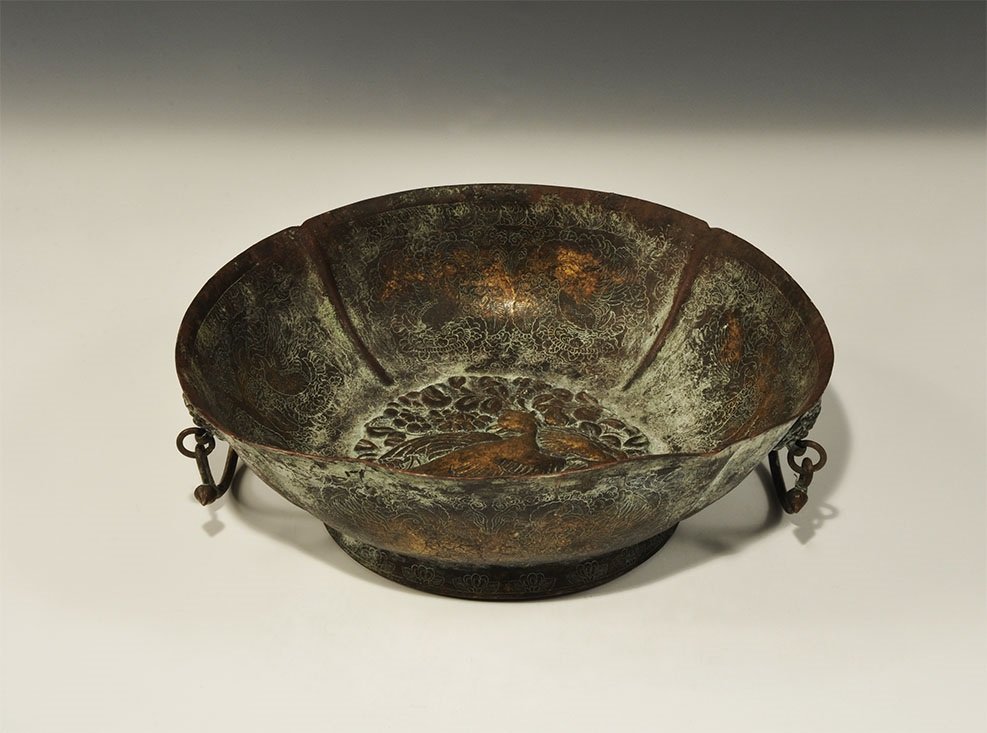 Chinese Style Bronze Repoussé Bowl: An undated archaistic sheet bronze bowl with flared base, central repoussé scene of birds amid foliage, engraved bird images to the inner and outer faces; two drop handles with lion-mask escutcheons.