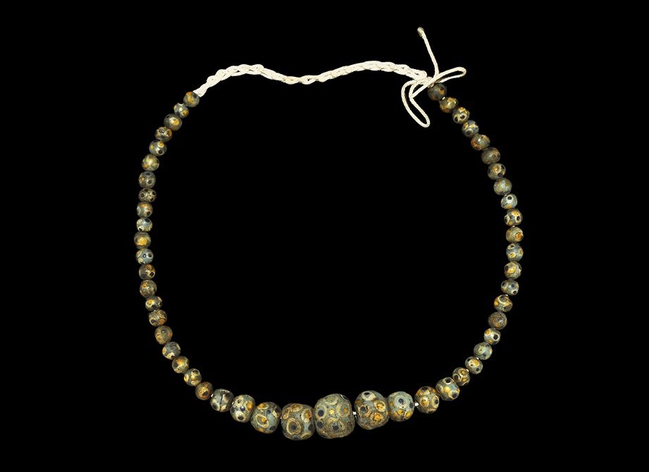 Indonesian Glass Bead Necklace: 20th century AD. A string of archaistic graduated green glass mosaic beads. 48 grams, 50cm (19 3/4"). Property of a London gentleman; acquired before 2000. TimeLine Auctions Ltd arranges printed catal
