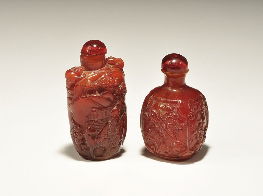 Chinese Style Composition Perfume Bottle Pair: A group of two undated archaistic cast perfume bottles comprising: one tall, elliptical in plan with domed lid, motif of a girl feeding cranes to one face and sage with a deer;one squat, square in pla