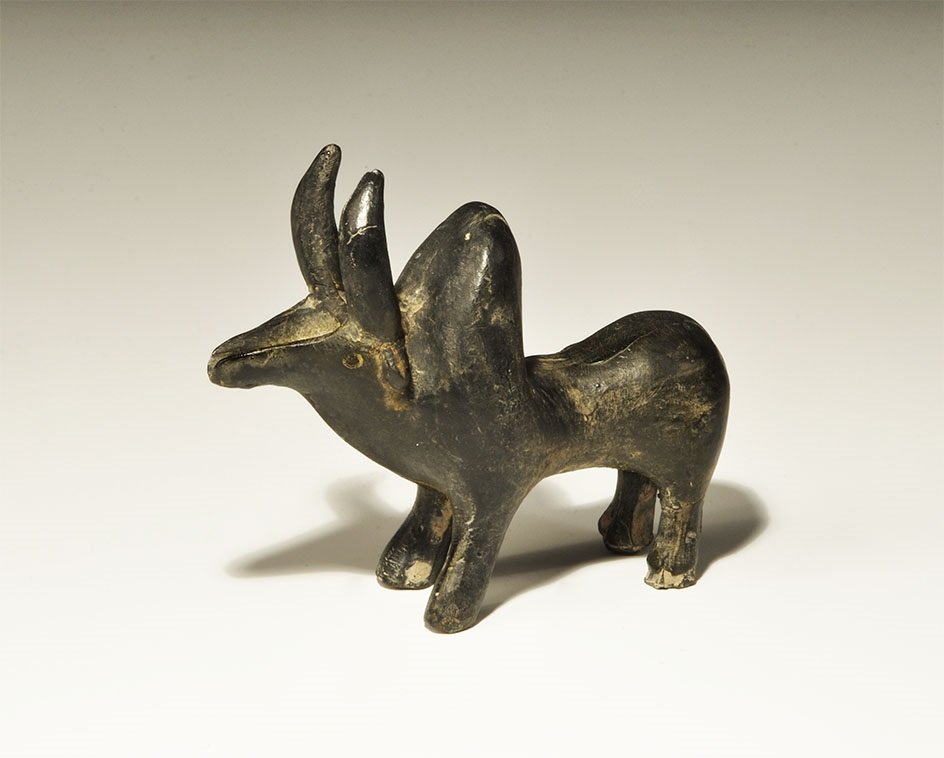 Near Eastern Anatolian Black Ceramic Bull Figurine: 1st millennium BC. A model bull with prominent horns, the face with pouring spout and reservoir to the upper surface. 157 grams, 10.5cm (4 1/4"). Private collection, North London; acquired in the earl