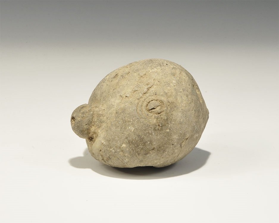 Byzantine Ceramic Greek Fire Grenade: 9th-11th century AD. A hollow ceramic vessel with domed top and conical base, deformed during manufacture; the body decorated with circumferential rings and roundels, discoid plaque to the shoulder an