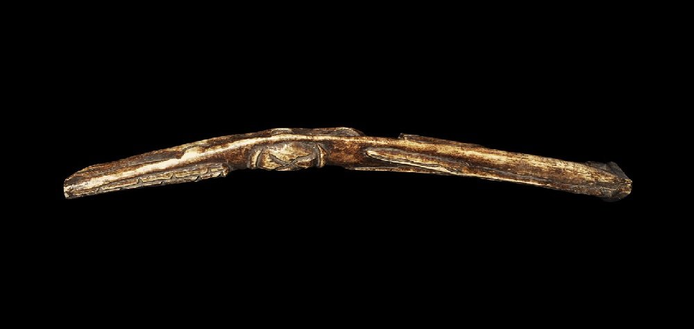 Ethnographic West African Bone Carved Staff: Early 20th century AD or earlier. A carved bone ritual implement with reserved snake and chalice to the outer face, Y-shaped and hatched panels to the inner face. 171 grams, 35cm (13 3/4"). Ex Steinbe